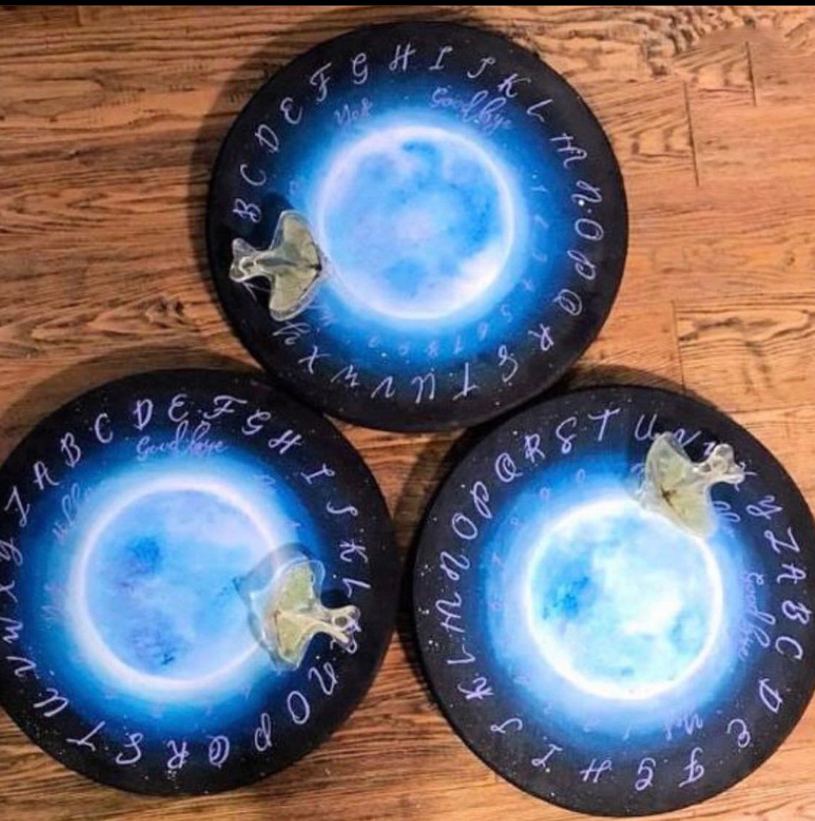 Three matching blue moon spirit boards with luna moth planchettes by Loren Morris